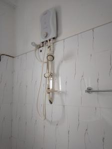 La salle de bains est pourvue d'une douche et de murs carrelés blancs. dans l'établissement Sea Garden Beach Resort, à Habaraduwa Central
