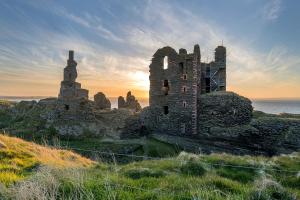 an old castle sitting on top of a hill at Self-catering Lighthouse Keeper's Cottage on the NC500 in Wick