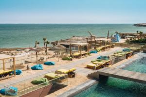 un complexe avec une piscine, des chaises et l'océan dans l'établissement Bavaro Beach Dakhla, à Dakhla