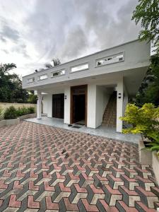 a large white building with a brick driveway at Colombo Reach Appartment By Layathraa in Kaduwela