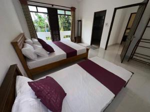 a bedroom with two beds and a large window at Colombo Reach Appartment By Layathraa in Kaduwela