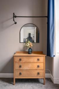 a dresser with a mirror on top of it at Vibrant Leith Flat in Edinburgh