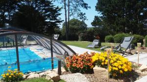 uma piscina com um ramo de flores ao lado em Maison vue mer avec piscine em Plouider