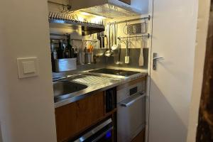 a small kitchen with a sink and a stove at Nice studio w balcony on Square Gardette in Paris - Welkeys in Paris