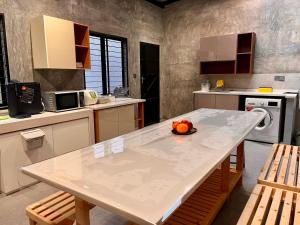 a kitchen with a table with a bowl of fruit on it at Traveler's Stay @ Ipoh (10Pax) in Ipoh