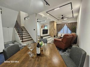 a living room with a table with a bottle of wine at Traveler's Stay @ Ipoh (10Pax) in Ipoh