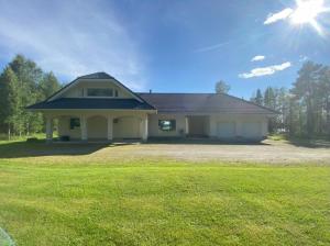 a house with a green lawn in front of it at Villa Saapunki in Kuusamo