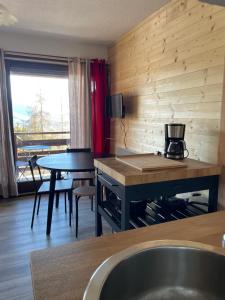 eine Küche und ein Esszimmer mit einem Tisch und einem Tisch in der Unterkunft Studio Chaillol 1600 in Saint-Michel-de-Chaillol