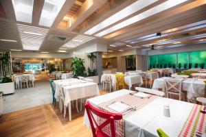 a dining room with white tables and chairs at Hotel Castellastva in Petrovac na Moru