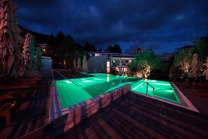 una piscina con luz verde por la noche en Hotel Castellastva, en Petrovac na Moru