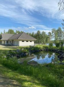 a house with a pond in front of it at Villa Saapunki in Kuusamo