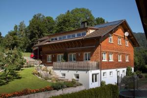 une grande maison en briques avec un toit dans l'établissement Appartment Hammerer, à Schwarzenberg im Bregenzerwald