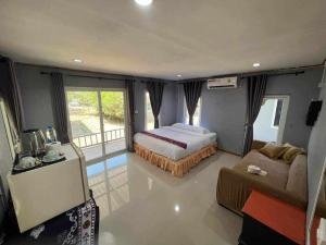 Un dormitorio con una cama y un sofá. en family resort, en Ko Phayam