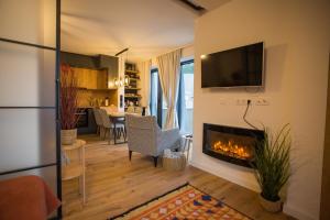 a living room with a fireplace and a tv at Aparthotel Phoenix in Bjelašnica