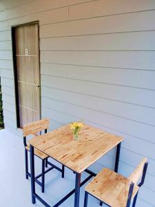 - une table en bois et 2 chaises sur la terrasse dans l'établissement family resort, à Ko Phayam