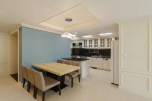 a kitchen with a table and chairs and a refrigerator at Pale De Cz Condo in Busan