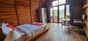 a bedroom with a bed and a wooden wall at Umah Nanda in Kubupenlokan