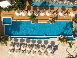 einen Blick über einen Pool mit Stühlen und Sonnenschirmen in der Unterkunft InterContinental Mauritius Resort Balaclava Fort, an IHG Hotel in Balaclava