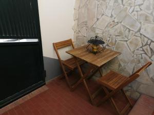 a table and two chairs and a stone wall at Chez Sam in Saint-Laurent-de-la-Salanque