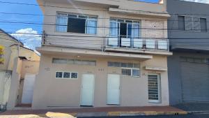 a building with two garage doors and a balcony at Kitnet recanto do mosteiro in Ribeirão Preto