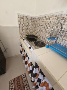 a kitchen with a stove and a tiled wall at Kavilla2 Regency in Karangploso