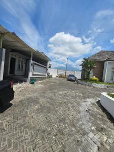 a house with a car parked in front of a driveway at Kavilla2 Regency in Karangploso
