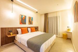 1 dormitorio con 1 cama grande con almohadas de color naranja en RA 35 by Majestic Properties, en Marrakech