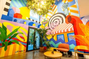 Cette chambre est dotée d'une fresque murale colorée. dans l'établissement The People - Paris Marais, à Paris