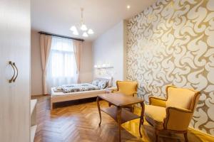 a bedroom with a bed and two chairs and a table at Standard Apartment by Hi5 - Rumbach - Synagogue in Budapest +7 photos