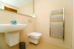 a bathroom with a sink and a toilet and a mirror at Modern 2 Bed Flat in East London in London