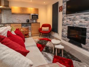 a living room with a couch and a fireplace at 2 Stoneleigh Cottage in Wrexham