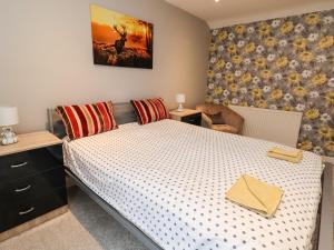 um quarto com uma cama com uma colcha branca em 2 Stoneleigh Cottage em Wrexham