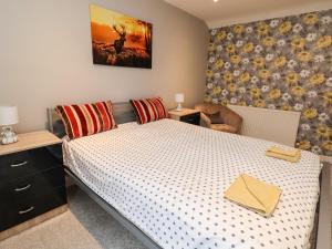 a bedroom with a bed with a white bedspread at 2 Stoneleigh Cottage in Wrexham