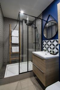La salle de bains est pourvue d'une baignoire, d'un lavabo et d'une douche. dans l'établissement Suite Madison, à Villeurbanne