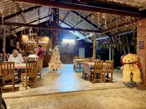 un restaurant avec un arbre de Noël et un grand ours en peluche dans l'établissement family resort, à Ko Phayam