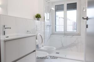 Baño blanco con aseo y lavamanos en Elegant Apartments in Lugano en Lugano