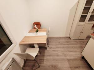 eine kleine Küche mit einem Holztisch und einem Stuhl in der Unterkunft STUDIO COSY PROCHE AEROPORT CDG in Arnouville-lès-Gonesse