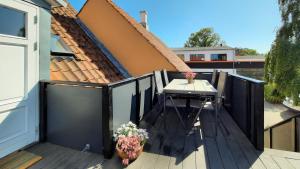 a wooden deck with a table and a house at Aroma Guesthouse in Ærøskøbing