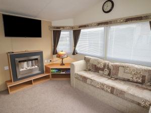 a living room with a couch and a flat screen tv at Berwyn View Holiday Home in Corwen