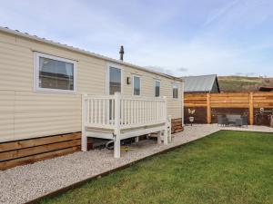 a mobile home with a bench in the yard at Berwyn View Holiday Home in Corwen