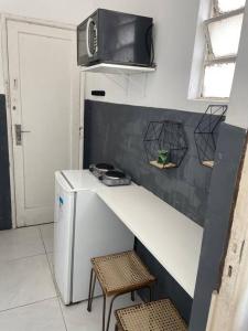 a small kitchen with a counter and a refrigerator at Loft funcional in Rio de Janeiro
