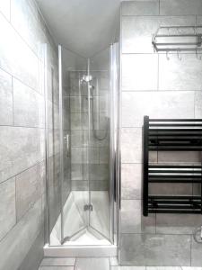 a shower with a glass door in a bathroom at Garden Flat in Edinburgh