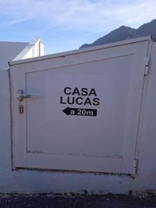 a white garage door with the words casa lucas on it at Casa lucas in Almáciga