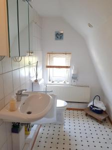 een badkamer met een wastafel en een toilet bij Muschelkästchen OG in Tönning