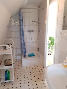 een badkamer met een douche en een bad bij Muschelkästchen OG in Tönning