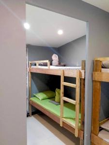 um quarto com 2 beliches com lençóis verdes em Mantilla Hostel em Coron