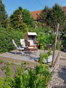 een tuin met een stoel, een tafel en een bank bij Muschelkästchen OG in Tönning