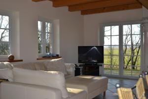 a living room with a white couch and a tv at Friesenhus in Katingsiel