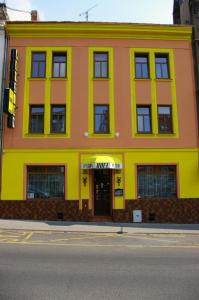 un bâtiment jaune et orange sur le côté d'une rue dans l'établissement Pension Duel, à Ústí nad Labem