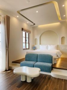 een slaapkamer met een bed en een blauwe bank bij Mellon OASIS Phu Quoc in Phu Quoc